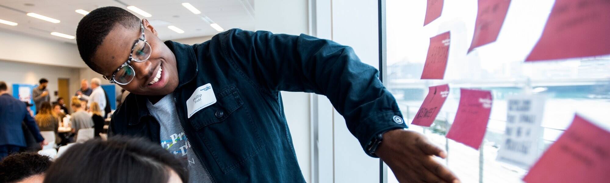 Students discuss sticky notes at a design thinking workshop